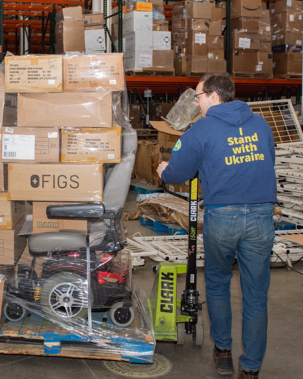 Volunteer moving a pallet of donated medical supplies in the CMA warehouse